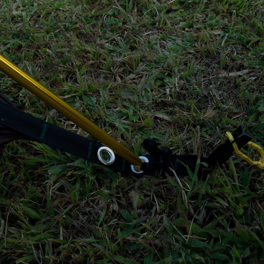 Section of a tent with a pole on grass