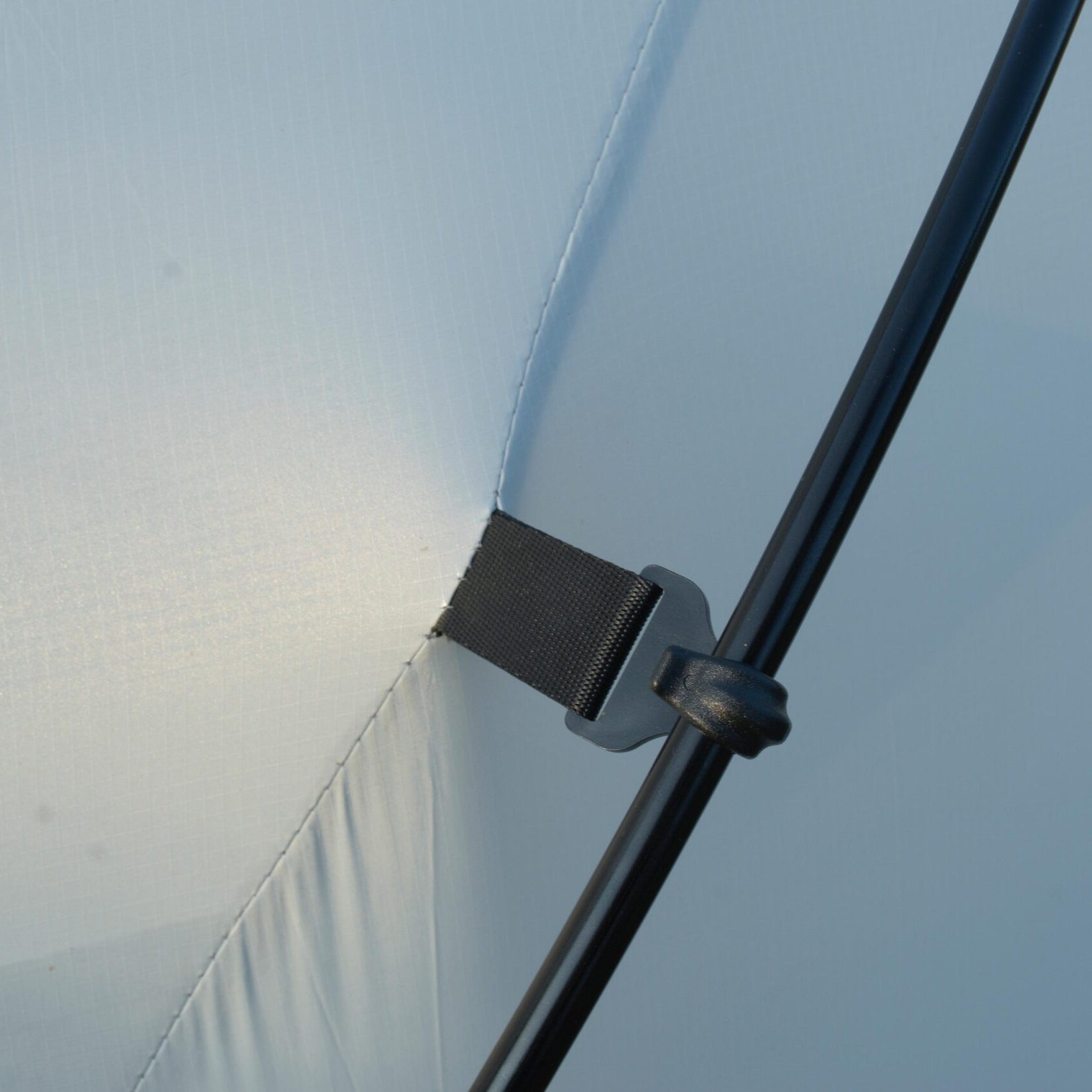 Close-up of a metal bracket on a transparent surface with a blurred background